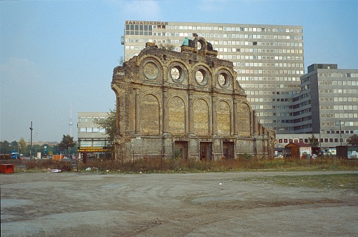 Mitte-Kreuzberg, Berlin, Germany, 1979. The ruin of the famous Anhalter Bahnhof at the Askanischer Platz in Berlin Mitte (West Berlin Times). He was at times the largest and most important railway station in Berlin. The war left only the front of the entrance hall (as seen here). The whole railway area was built from the 80s of the last century new. In the background the Excelsior House with its nuclear bunker in the underground of the Cold War. Just behind the building was the Iron Curtain (Churshill).