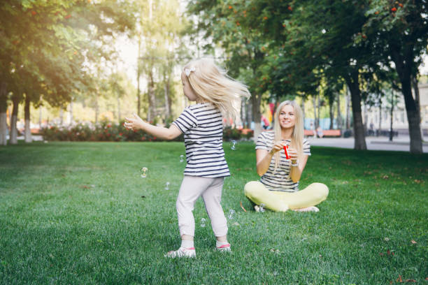 istock Mother and her little daughter inflate soap bubbles 913441700