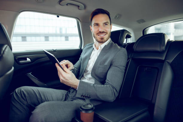 istock Businessman in a car using digital tablet and smiling 913452896