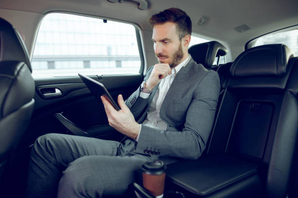 istock Businessman in a car using digital tablet 913458350