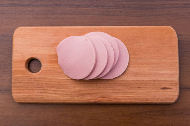 istock Sliced boiled sausage on cutting board on wooden table 913469854