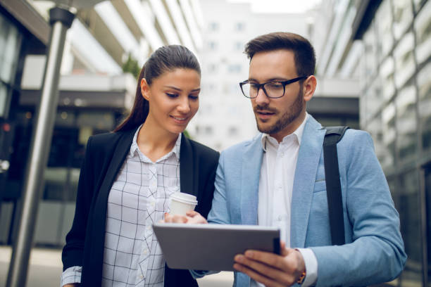 istock Business team discussing business project using tablet computer outdoors 913475258
