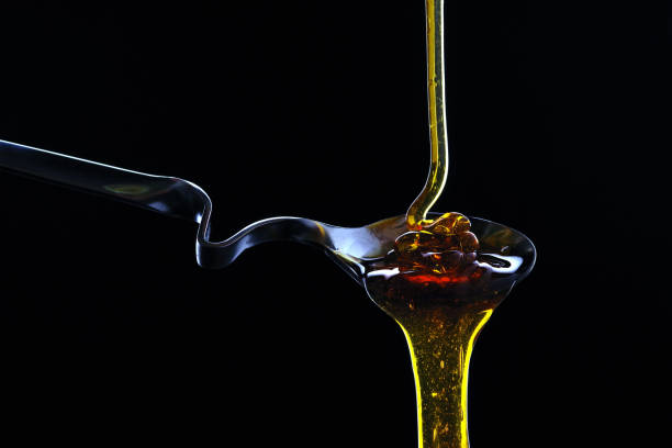 istock Spoon with honey on a black background. 913476402