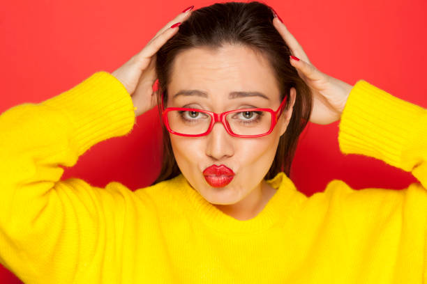 istock beautiful woman with red glasses on red background 913476418