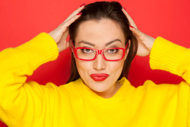 istock beautiful woman with red glasses on red background 913476426