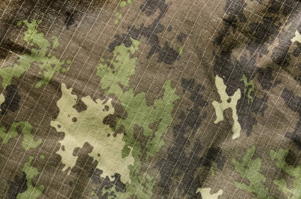 istock Military camouflage fabric texture background 913476518