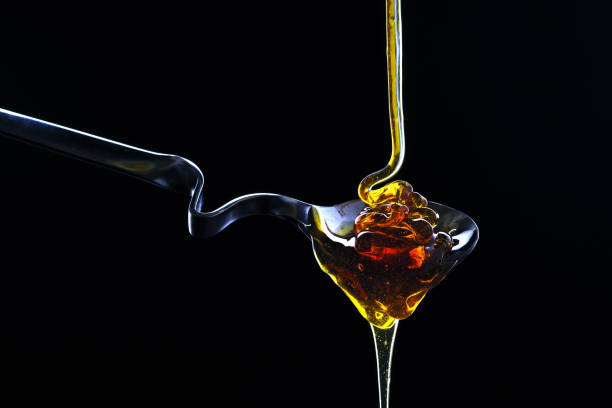 istock Spoon with honey on a black background. 913476650