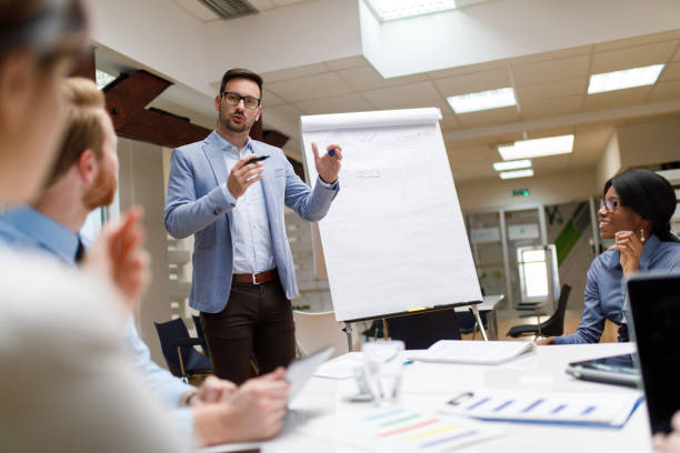 hombre de negocios que presenta el nuevo proyecto a los socios en la oficina - education business people men fotografías e imágenes de stock