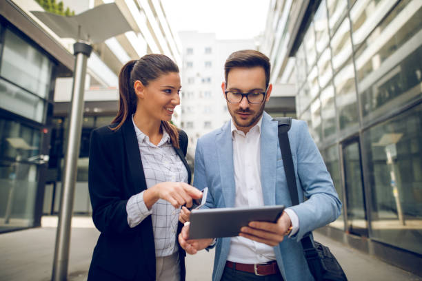 istock Business team discussing business project using tablet computer outdoors 913481892