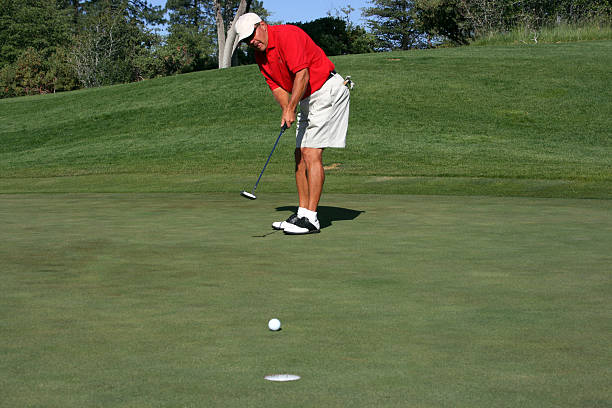 istock Man about to make putt, focus on golfer 91348739