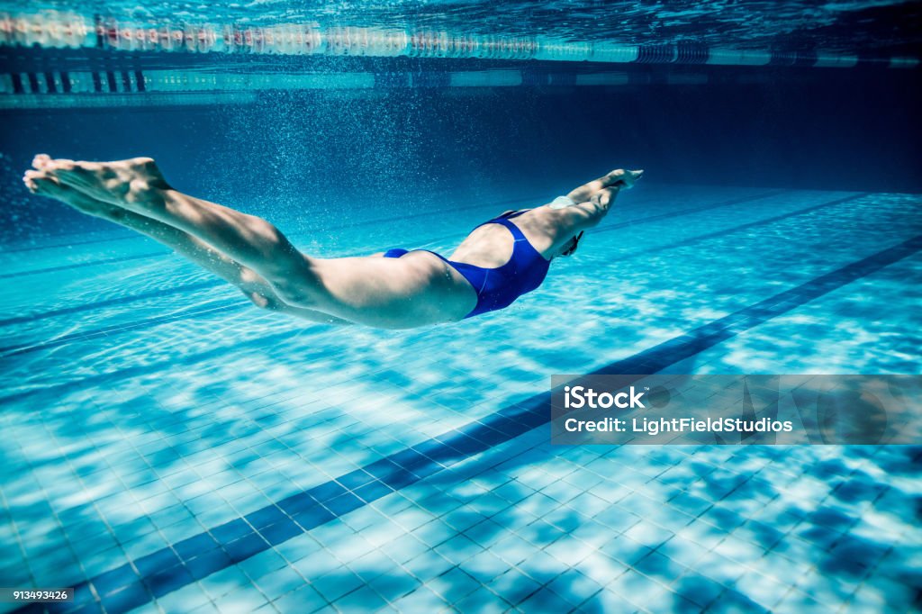 photo sous-marine de l’exercice de la jeune nageuse en piscine - Photo de Natation libre de droits