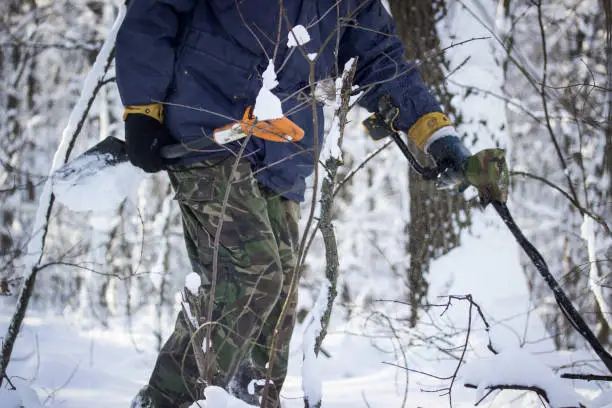 winter walk through the forest with a metal detector and a sapper shovel is a bright day that you need for outdoor activities in nature