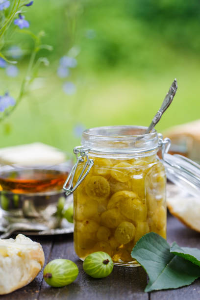 Green gooseberry jam on a wooden table stock photo