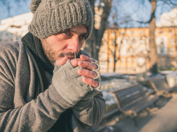 かわいそうにホームレスの若い男は、紅茶やコーヒーのホットカップを保持 - homelessness human hand dirty unhygienic ストックフォトと画像