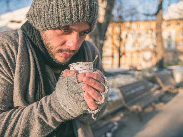 悲しい若者貧困で紅茶やコーヒーのホットカップを保持している乞��食 - homelessness human hand dirty unhygienic ストックフォトと画像