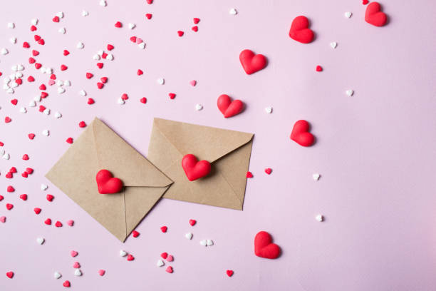istock Two craft paper postal envelope with multicolor sweet sugar candy hearts. Love message or gift concept. 913507750