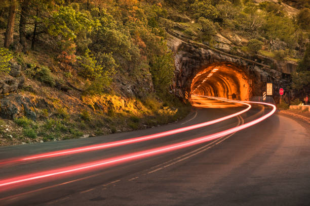 Light trails from a car move into a tunnel on the road
