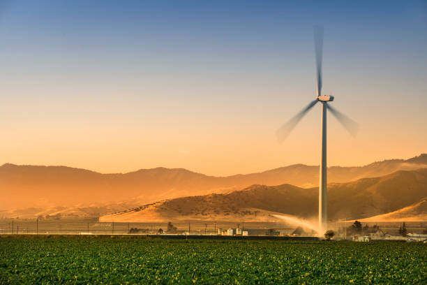 Renewable energy wind turbine at arvest time on an agricultural field in the Salinas Valley, California USA