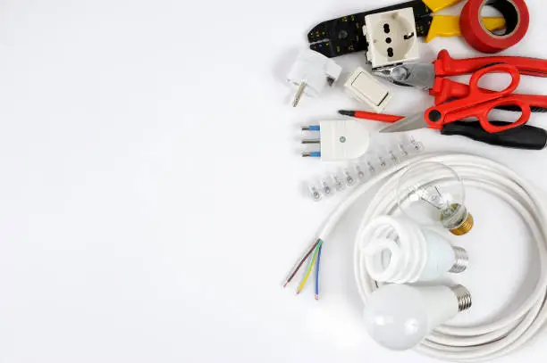 Photo of Top view of working tools and components of the electrical system on white background.