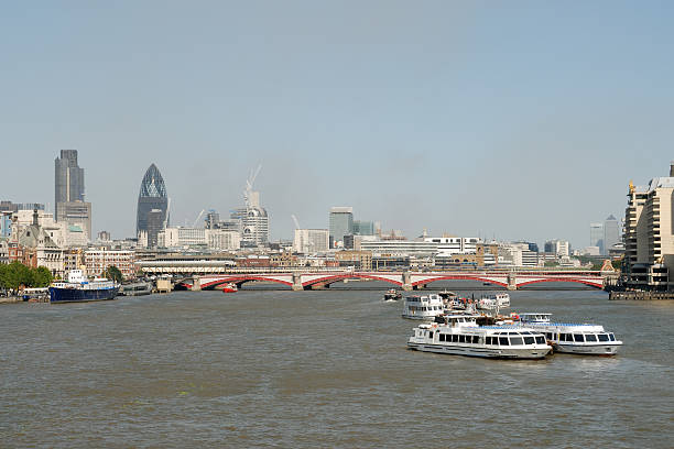 View across the river Thames in the centre of London, UK.  People can be seen on the promenade