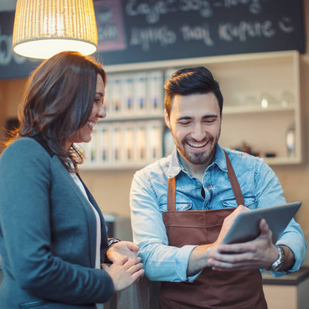 istock Barista and customer using digital tablet in coffee shop 913521852