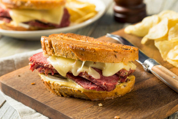 Savory Homemade Corned Beef Reuben Sandwich Savory Homemade Corned Beef Reuben Sandwich with Mustard and Cheese pastrami photos stock pictures, royalty-free photos & images