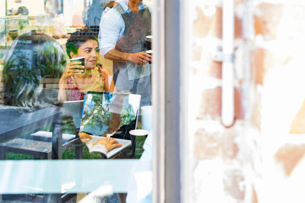istock View through a window of a woman working in a cafe 913534438