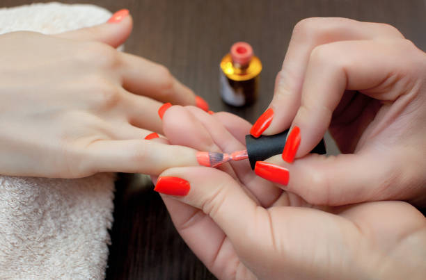 o mestre da manicure pinta as unhas com esmalte durante o procedimento de extensões de unhas com gel no salão de beleza. cuidados profissionais para as mãos. - acryle - fotografias e filmes do acervo