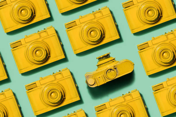 istock Vintage yellow cameras laying on green background 913556908