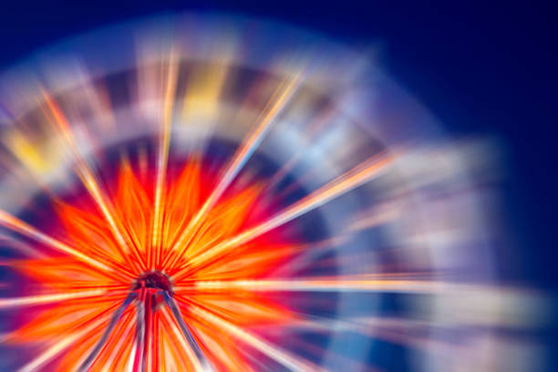 exposition longue d’une roue de ferris coloré et lumineux dans la nuit. - ferris wheel wheel blurred motion amusement park photos et images de collection