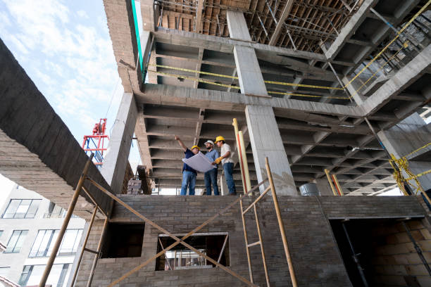 istock Group of architects looking at a blueprint at a construction site 913566970