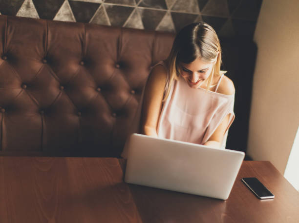 istock Young woman working on laptop in the cafe 913578552