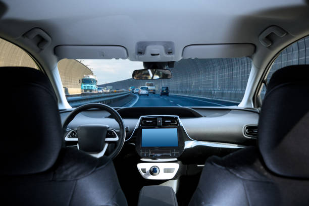 Cockpit of driverless car driving on highway viewed from rear seat. Cockpit of driverless car driving on highway viewed from rear seat. driverless car stock pictures, royalty-free photos & images