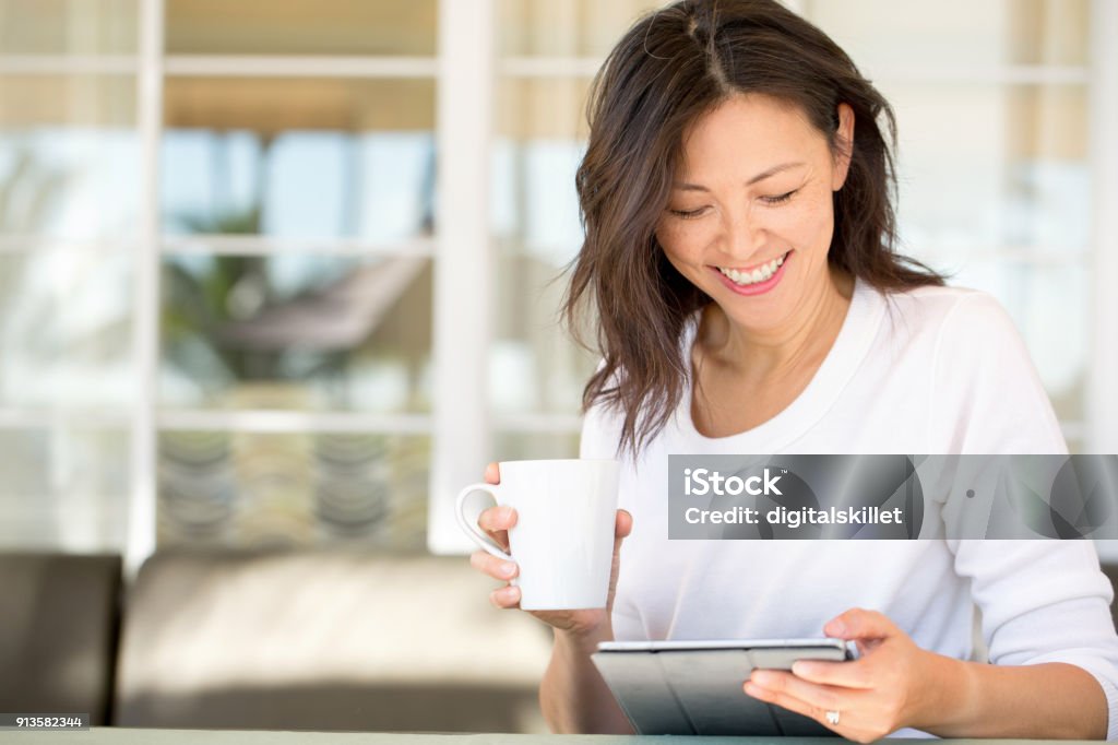 Portrait of an Asian woman smiling. Portrait of an Asian woman laughing and smiling. Digital Tablet Stock Photo