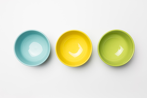 Colored bowls on white background