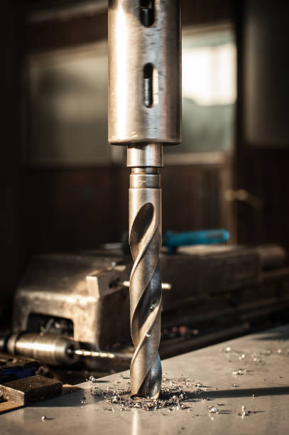 istock Automatic heavy industrial drill bit cutting metal block at factory 913598448