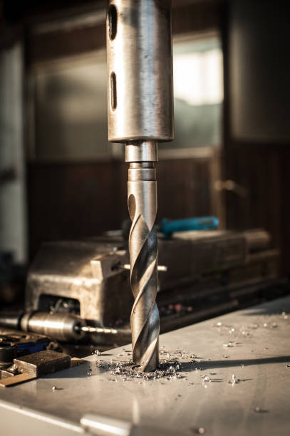 istock Automatic heavy industrial drill bit cutting metal block at factory 913598518