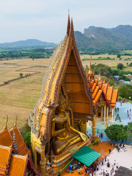 巨大な仏像にフィールドと背景の山 - tiger cave temple kanchanaburi province ストックフォトと画像