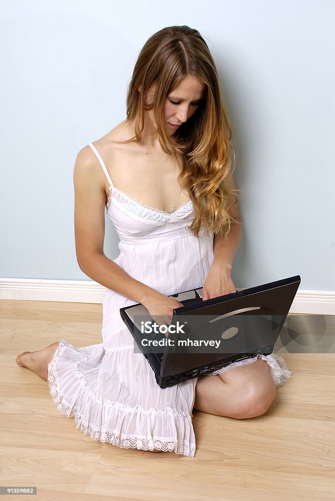 Joven mujer en vestido mirando a la computadora portátil - Foto de stock de Adulto libre de derechos