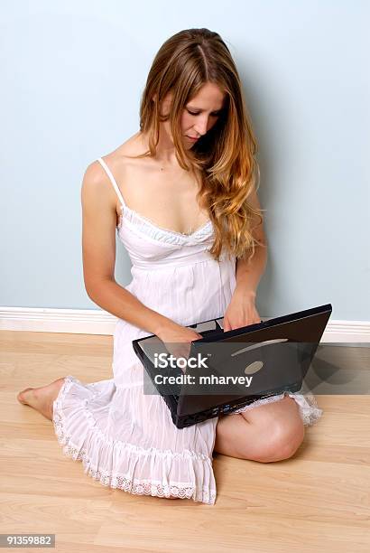 Joven Mujer En Vestido Mirando A La Computadora Portátil Foto de stock y más banco de imágenes de Adulto