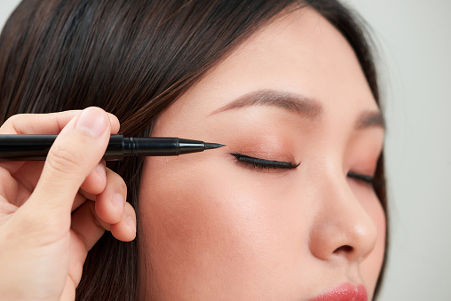 Close-up of beautiful woman make-up with black eyeliner.