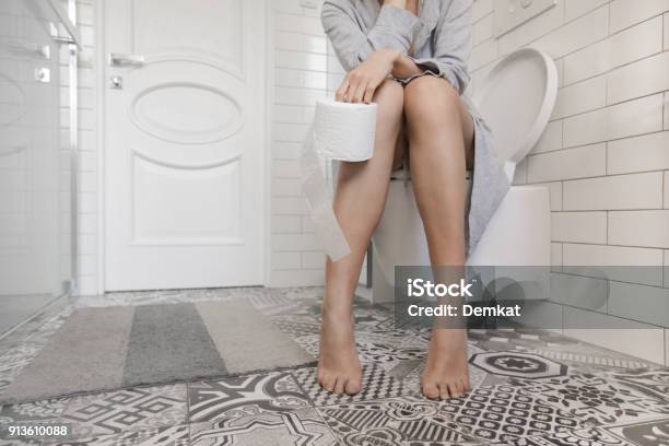 Frau Sitzt Auf Der Toilette Mit Wcpapier Stockfoto und mehr Bilder von Verstopfung - Verstopfung, Toilette, Frauen