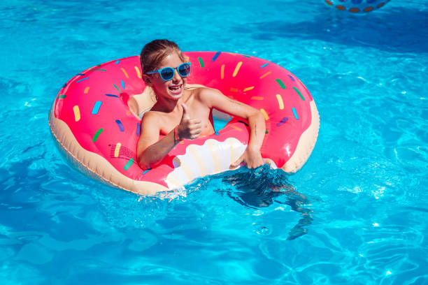 istock Girl on inflatable ring in swimming pool 913616982