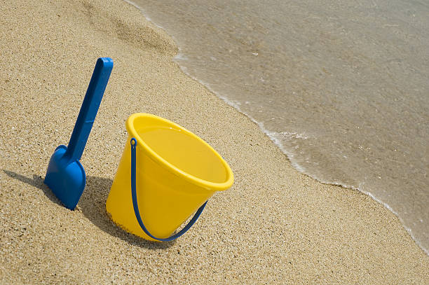 Childrens toy bucket and spade by the ocean shore