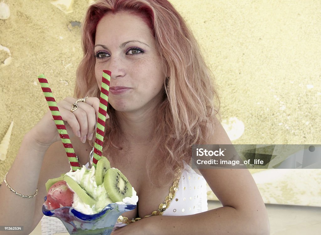 Молодая женщина ест мороженое - Стоковые фото 18-19 лет роялти-фри