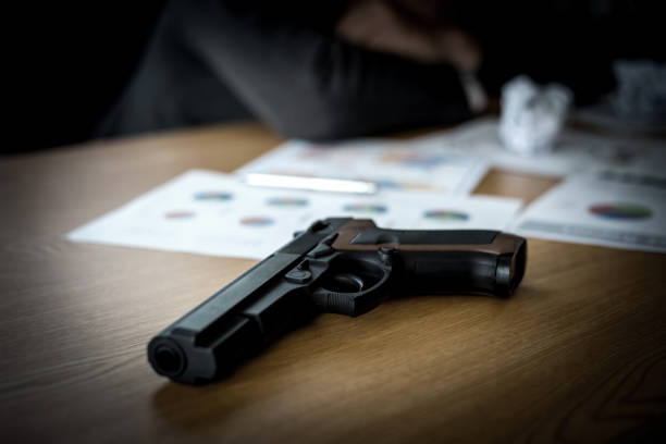pistolet et nous billet d’un dollar sur le bureau - currency crime gun conflict photos et images de collection