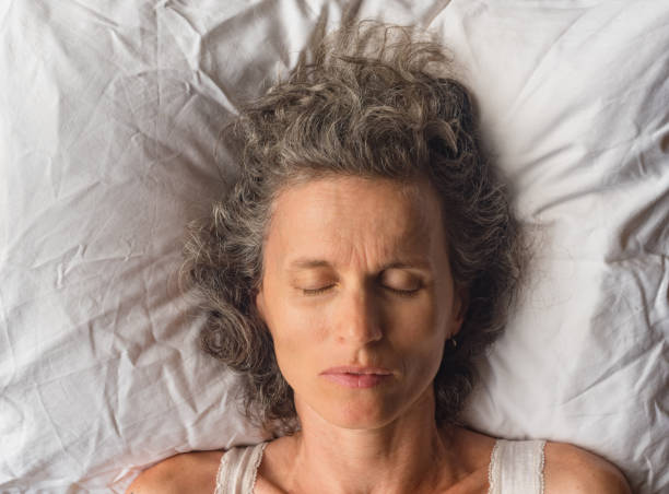 High angle close up view of middle aged woman sleeping on pillow (selective focus)