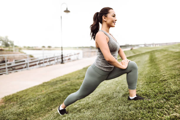 donna fitness che si estende nell'erba - overweight women weight loss foto e immagini stock