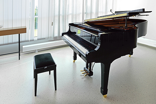 Black grand piano in empty room