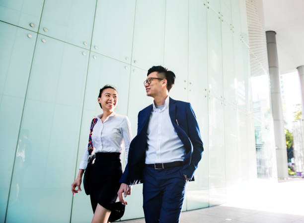 Asian business people discussing while walking Asian business people discussing while walking chinese script photos stock pictures, royalty-free photos & images